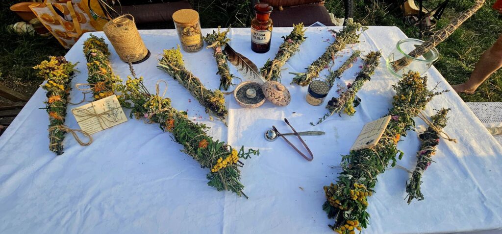 Ein Tisch mit verschiedenen Kräuterbünden und Utensilien.